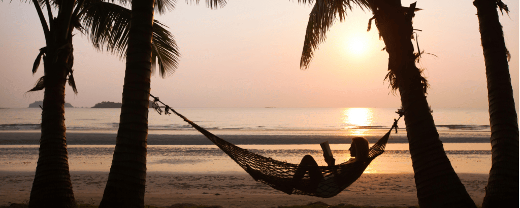 Woman in hammock reading on a beach vacation